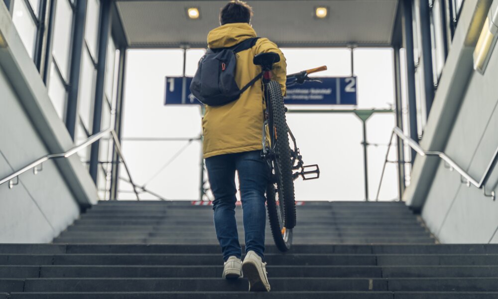 Mann trägst sein Fahrrad am Bahnhof die Treppe hoch  | ©  Getty Images/ Lorenzo Capunata