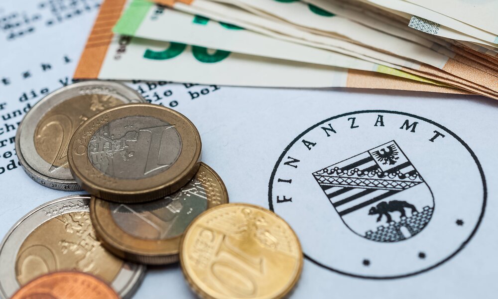 Kleingeld und schreiben vom Finanzamt | © IMAGO / Zoonar