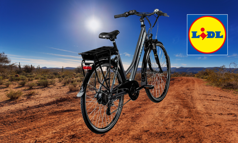 Schwarzes E-Bike steht auf sandigem Wüstenweg unter klarem Himmel am Tag. | © Lidl