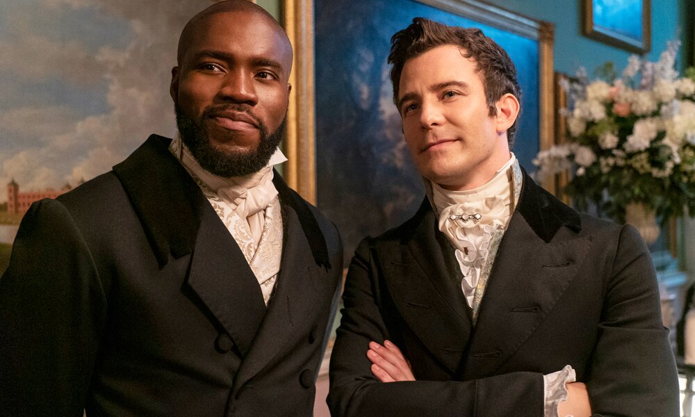 Will Mondrich (Martins Imhangbe) und Benedict Bridgerton (Luke Thompson) unterhalten sich amüsiert in einer Szene aus der Netflix-Serie "Bridgerton" | © Netflix/Liam Daniel