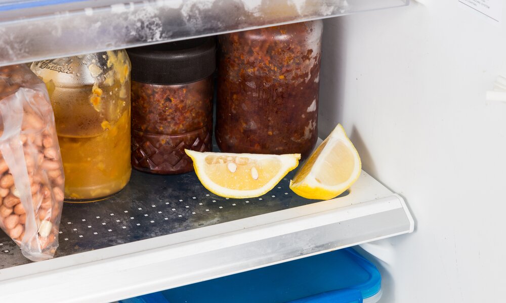 Aufgeschnittene Zitronenstücke neben Gläsern mit eingemachten Soßen im Kühlschrank. | © Getty Images/ ThamKC