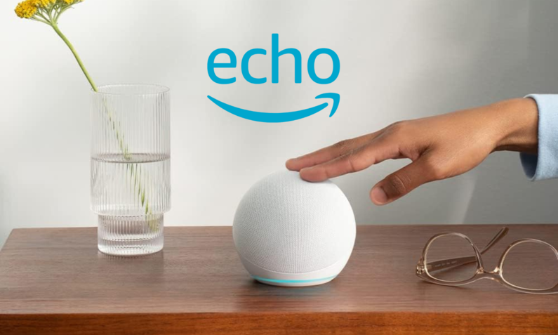 Amazon Echo Dot auf einer Kommode, eine Frauenhand tippt ihn an, daneben eine Blumenvase | © Amazon