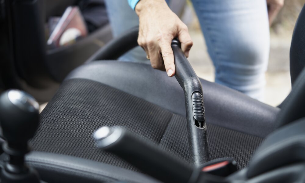 Frau saugt Autositz | © Getty Images/ aire images