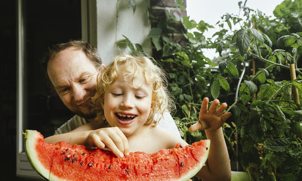 Vater und Sohn mit Melonenspalte | © Getty Images/ Westend61