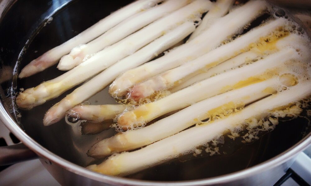 Weißer Spargel kocht in einem Topf voll Wasser und etwas Butter. | © Getty Images / Rocky89