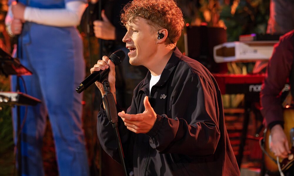 Tim Bendzko singt leidenschaftlich auf einer Bühne, umgeben von Musikern und Instrumenten. | © RTL/Markus Hertrich