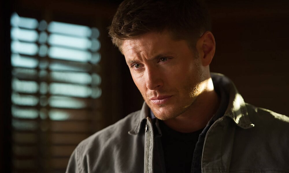 Nahaufnahme von Jensen Ackles als Dean Winchester mit düsterem Gesichtsausdruck in einer Szene der TV-Serie "Supernatural" | © Imago Images/Everett Collection