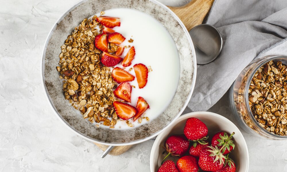 In einer Müslischüssel in einer Reihe angeordnet Granola, Erdbeeren, Chiasamen und Joghurt. | © Getty Images / Alexandr Kolesnikov