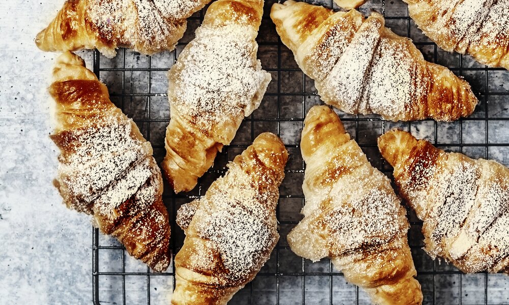 Croissants auf Gitterrost bestreut mit Puderzucker. | © Getty Images / 	Claudia Totir