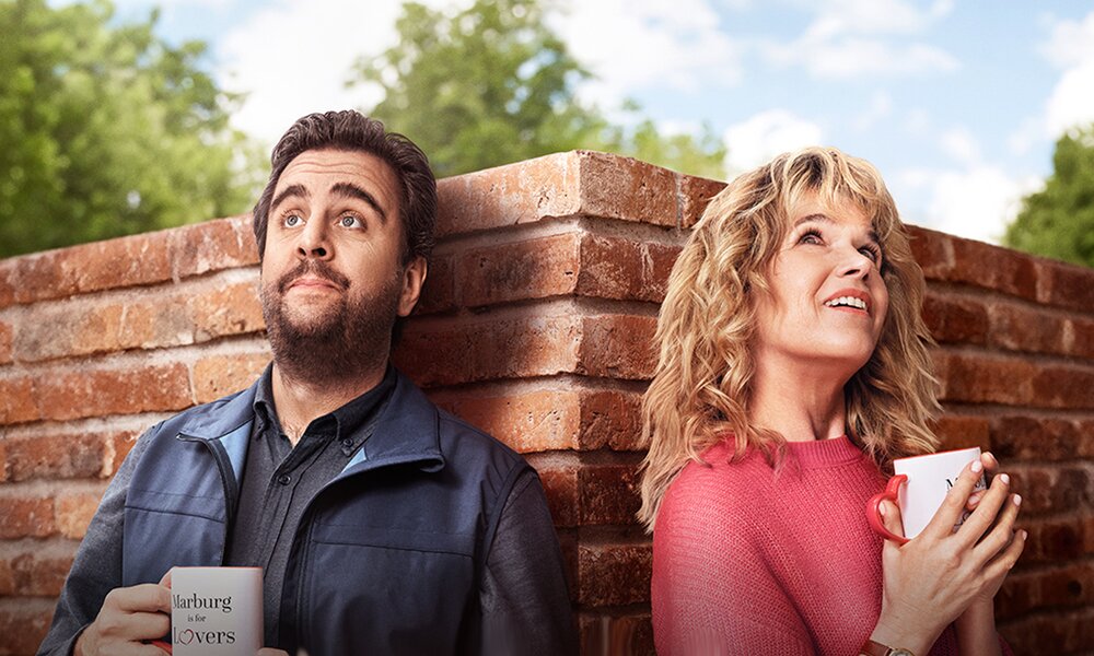 Bstian Pastewka und Anke Engelke lehnen sich auf der Key Art zur Prime Video Serie "Perfekt verpasst"  auf verschiedenen Seiten einer Mauerecke | © Prime Video