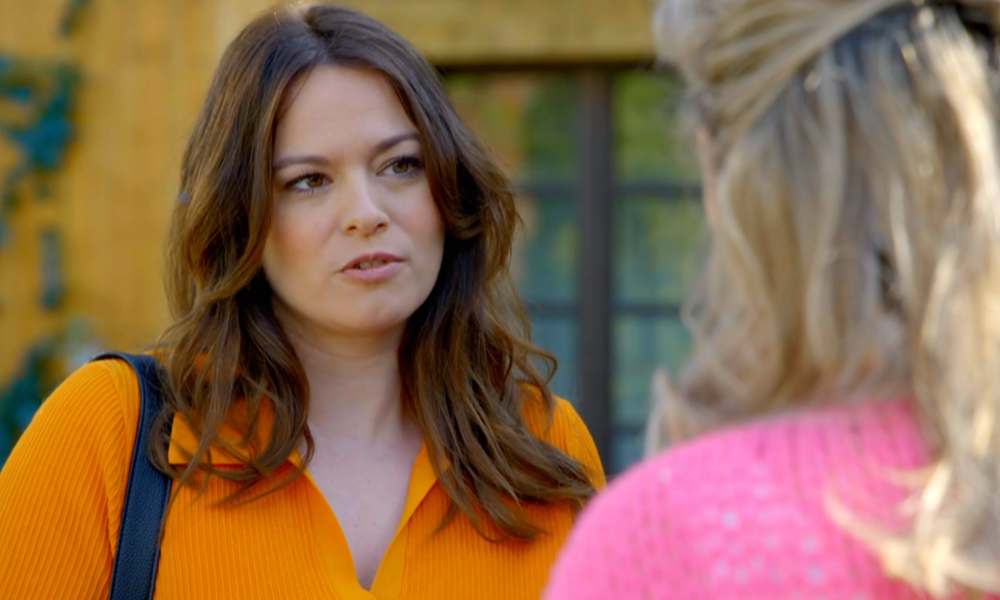 Frau mit brauen Haaren und orangefarbenem Pullover guckt nachdenklich. | © SAT.1/Screenshot