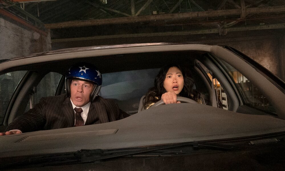 John Cena und Awkwafina sitzen in einer Szene aus dem Prime-Video-Originalfilm "Jackpot" in einem Auto bei Nacht | © Prime Video