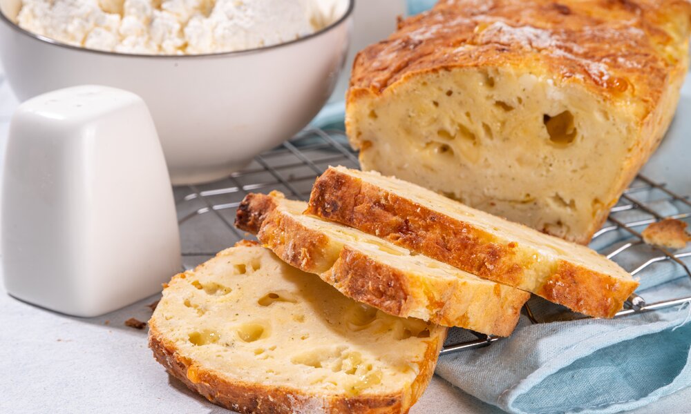 Angeschnittenes luftiges Hüttenkäse-Brot auf einem Abkühlgitter. | © Adobe Stock / ricka_kinamoto