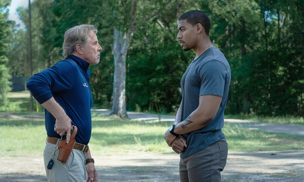 Don Johnson steht als Police Chief Aaron Pierre gegenüber und zieht die Waffe in einer Szene aus dem Netflix-Film "Rebel Ridge" | © Netflix/Allyson Riggs
