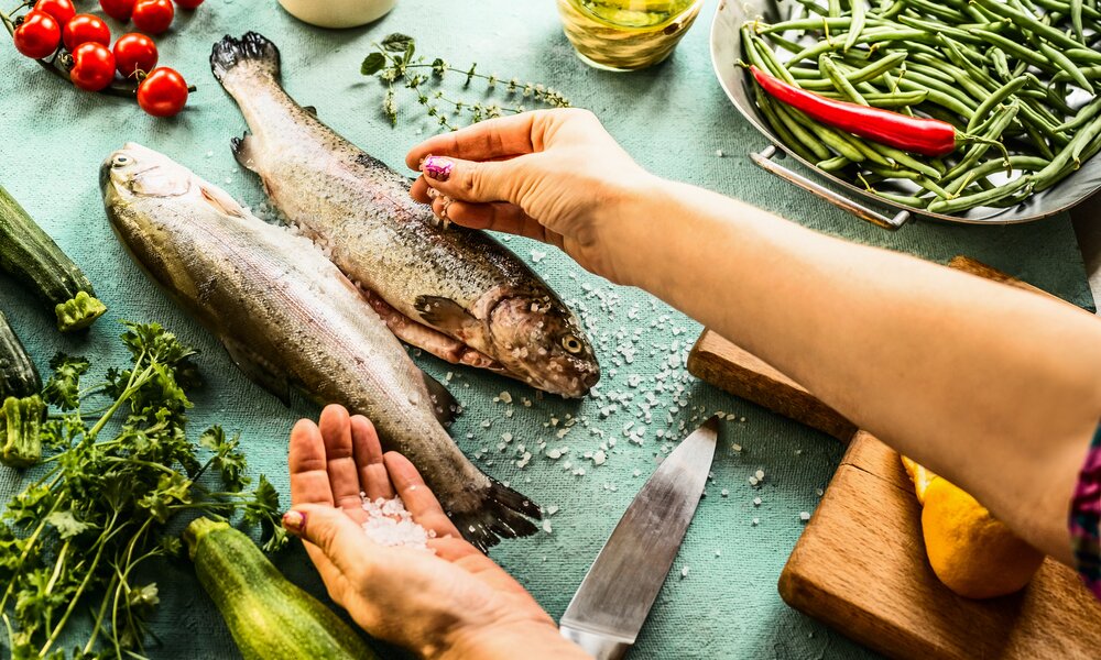 Fisch wird gesalzen | © Getty Images / VICUSCHKA