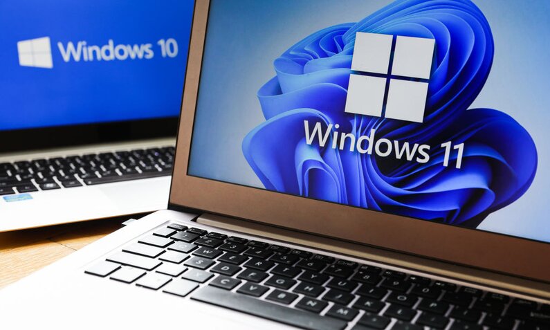 Zwei Computer-Laptops, auf einem Bildschirm ist Windows 10 zu sehen, auf dem anderen windows 11. | © Getty Images/NurPhoto