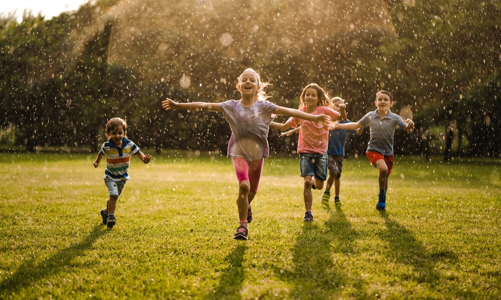 Kinder laufen durch den Sommerregen  | ©  Getty Images / StockPlanets