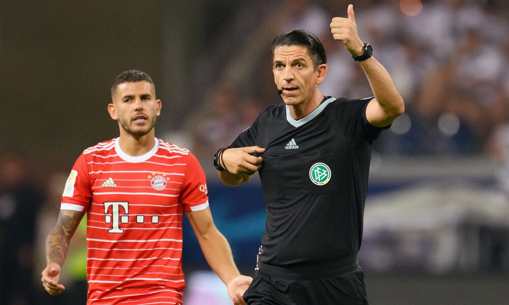 Schiedsrichter Deniz Aytekin und ein Spieler laufen übers Feld im Bundesliga-Matchzwischen Eintracht Frankfurt und FC Bayern München im August 2022 im Frankfurter Stadion.  | © Getty Images/